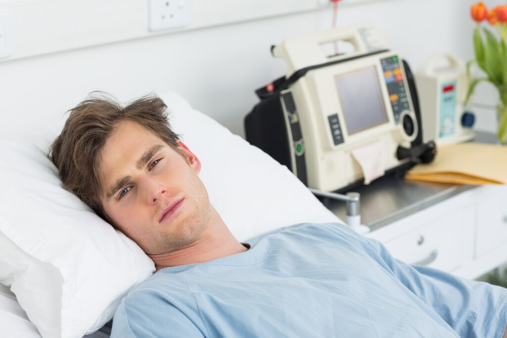 salarié homme trentaine allongé dans un lit d'hôpital